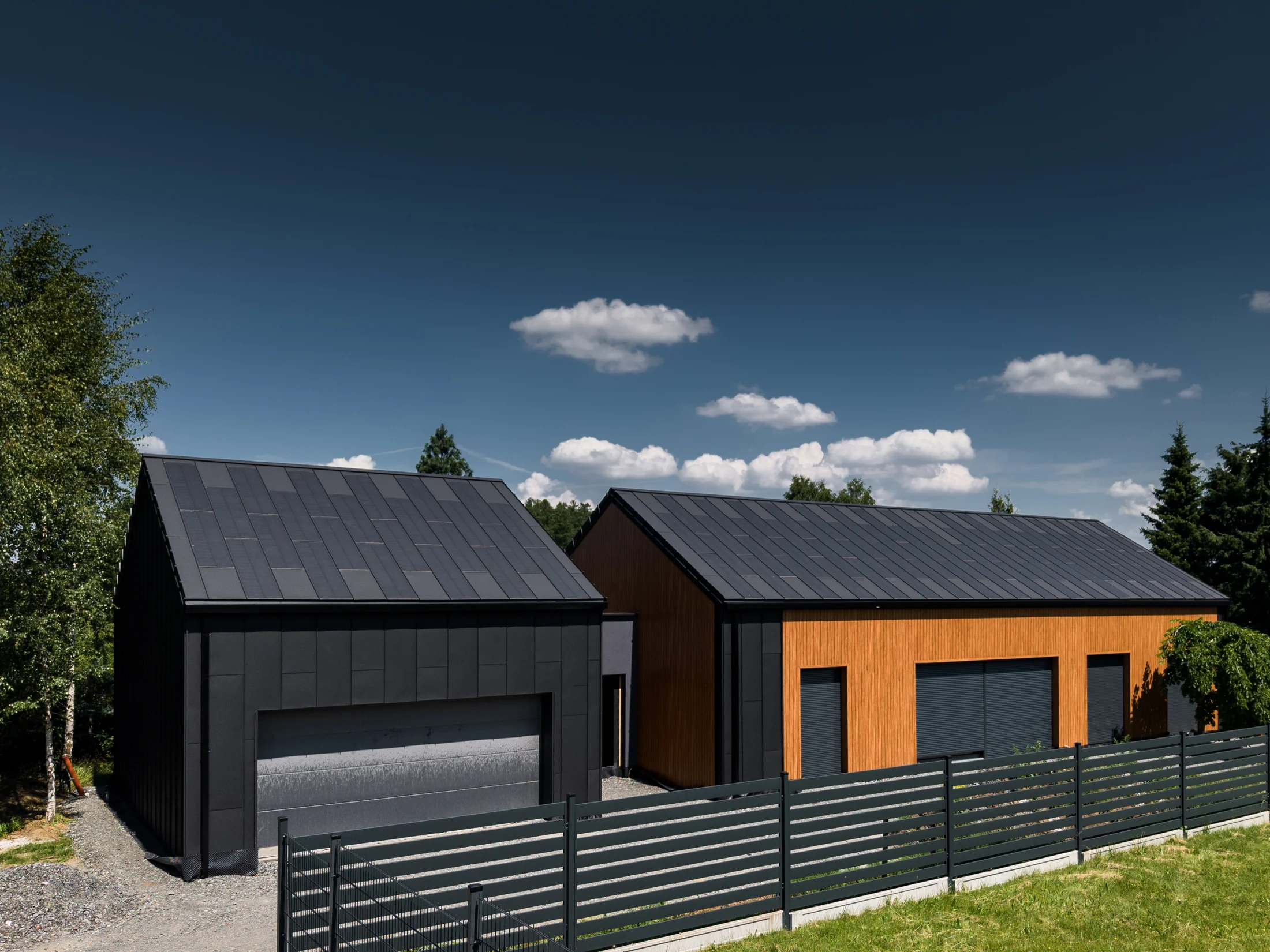 Contemporary homes with dark roofs and timber façades